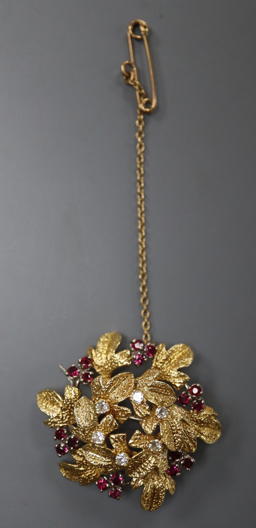A modern 18ct gold, ruby and diamond cluster set circular two tier leaf brooch, 35mm, gross 12.3 grams.